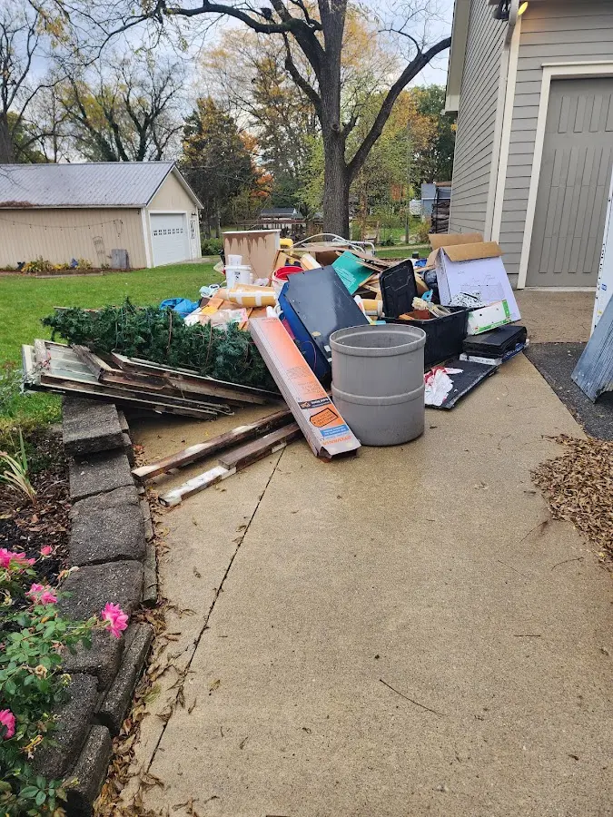 Dumpster being loaded with debris for Estate Cleanout Dumpster Rental in Hartland
